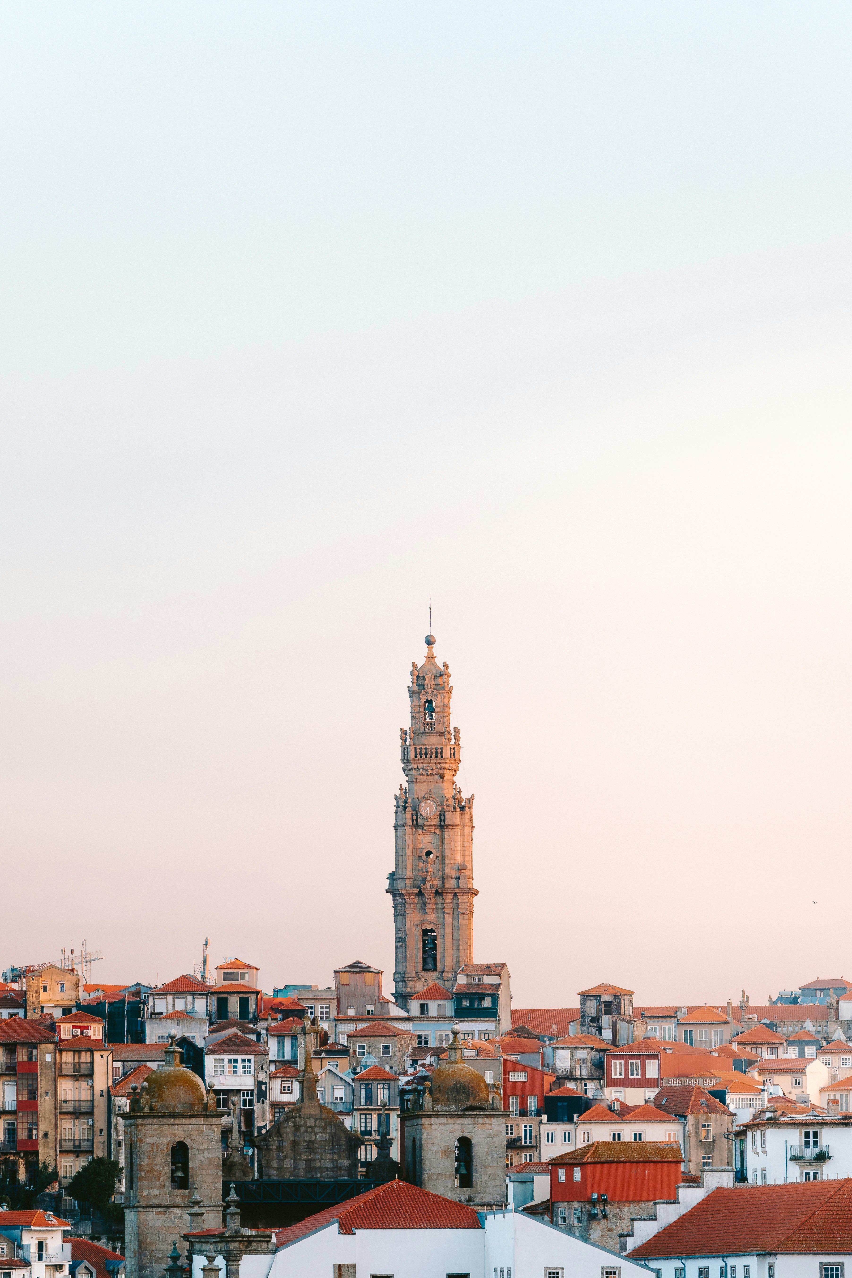 Clérigos Tower rising above the rooftops of Porto, Portugal, at sunset