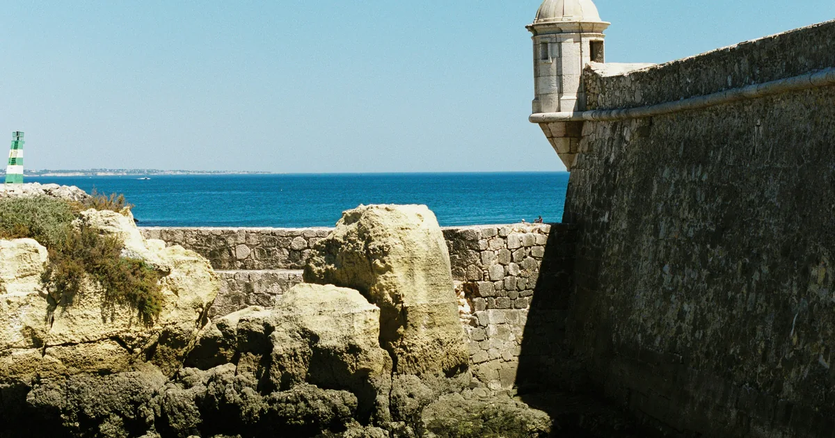 Stone seaward wall and sentry turret above limestone rocks, with open Atlantic water beyond
