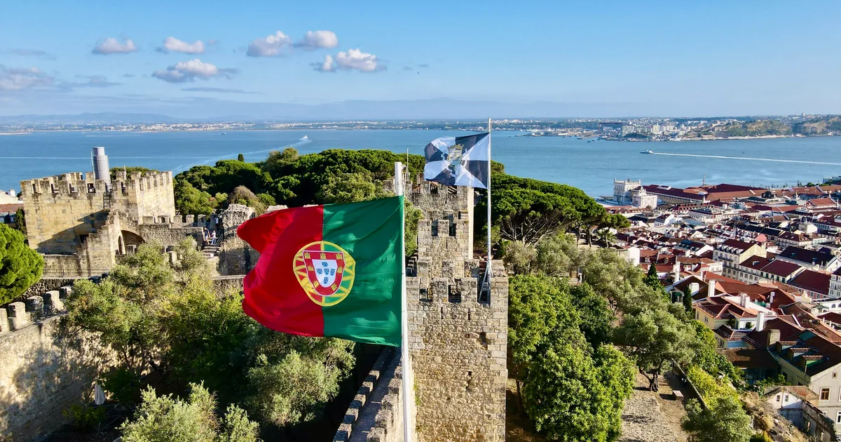 Portuguese and Lisbon flags on São Jorge castle walls, looking over the Tagus